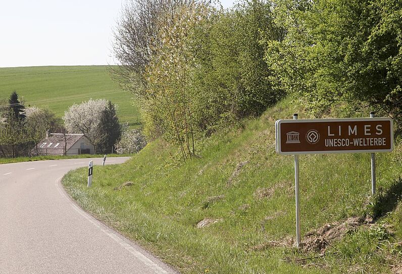 Abbildung Ortseingang Pfahlbach mit Tafel Limes Weltkulturerbe